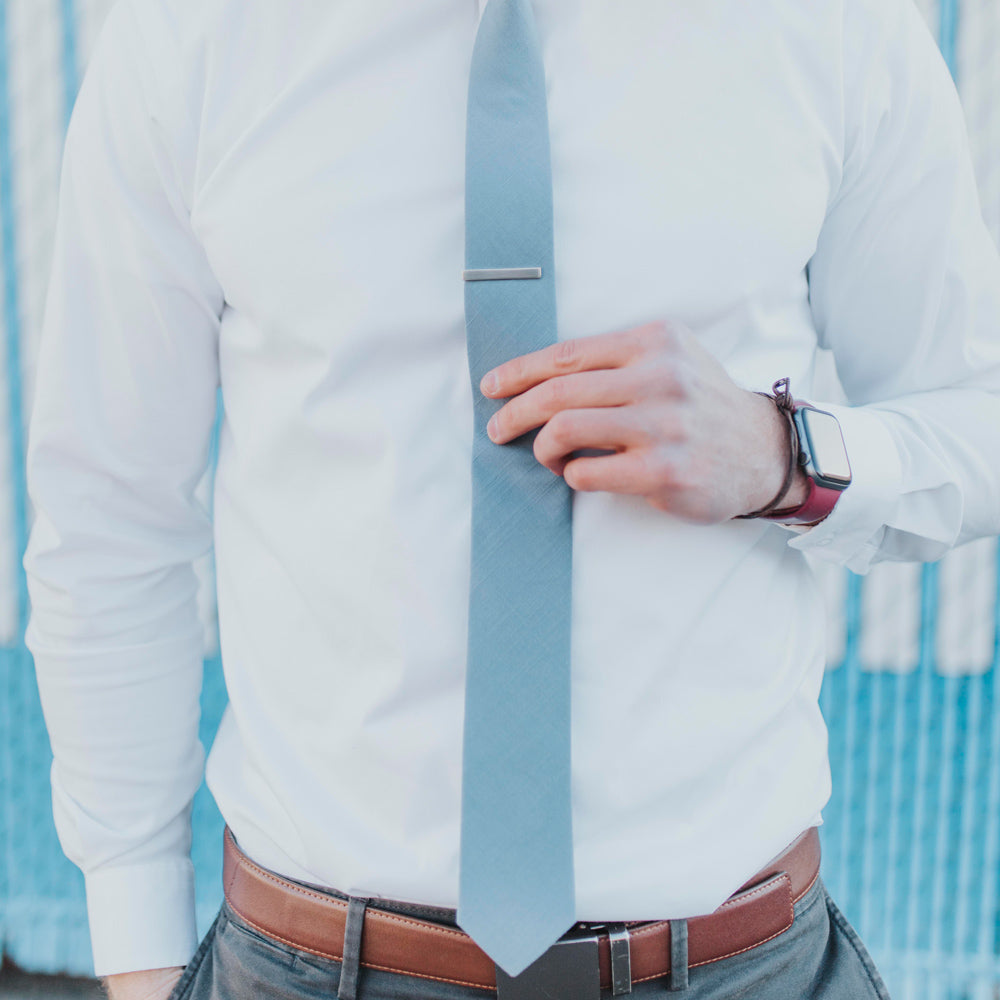 DAZI solid blue necktie worn with a white long sleeve shirt.