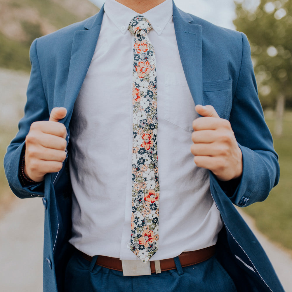 Orange Pansy floral necktie worn with a white shirt and a blue suit.