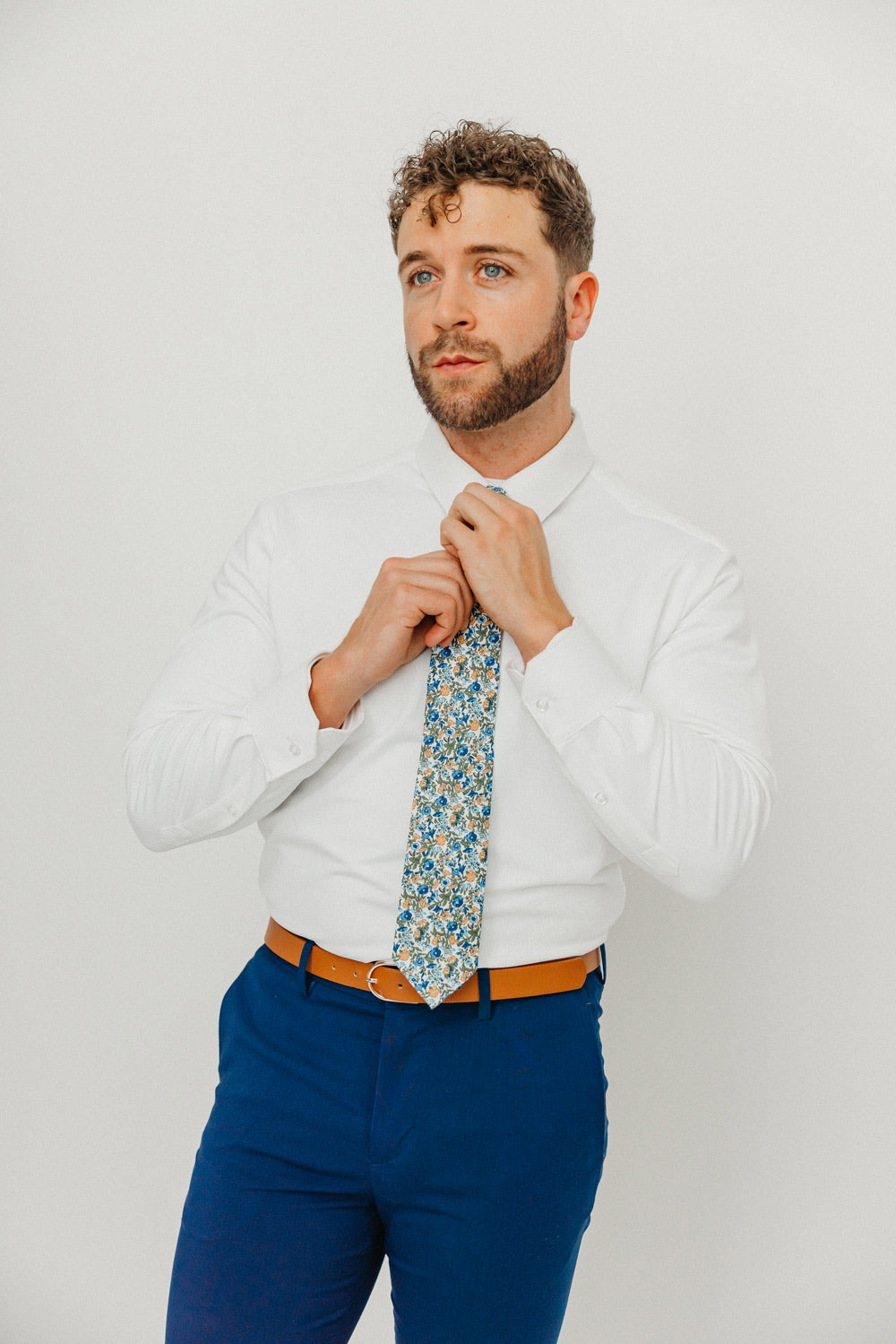 Alpine Blum tie worn with a white shirt, brown belt and blue pants.