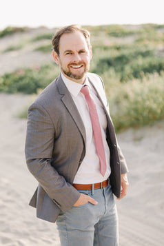 Dusty Rose Tie worn with a white shirt, gray suit jacket and blue pants.