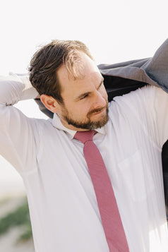 Dusty Rose Tie worn with a white shirt and gray suit jacket.