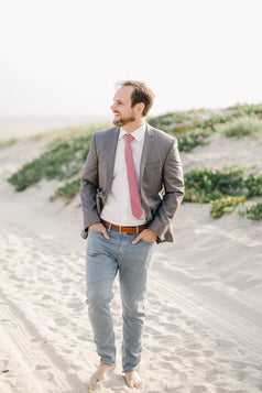 Dusty Rose Tie worn with a white shirt, gray suit jacket and blue pants.