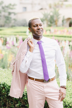 Grape tie worn with a white shirt and light pink suit.