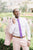 Grape tie worn with a white shirt and light pink suit.