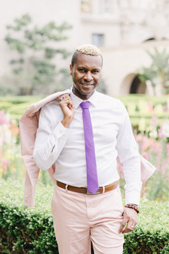 Grape tie worn with a white shirt and light pink suit.