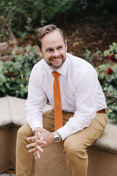 Pumpkin tie worn with a white shirt and tan pants.