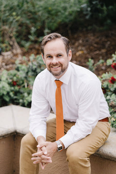 Pumpkin tie worn with a white shirt and tan pants.