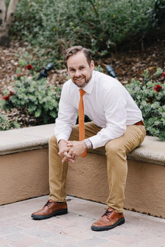 Pumpkin tie worn with a white shirt and tan pants.