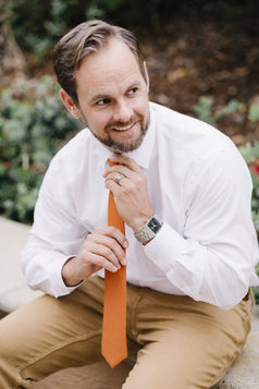 Pumpkin tie worn with a white shirt and tan pants.