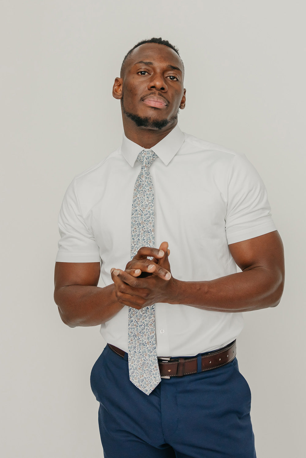 Scorpion Grass tie worn with a white shirt, brown belt and blue pants.