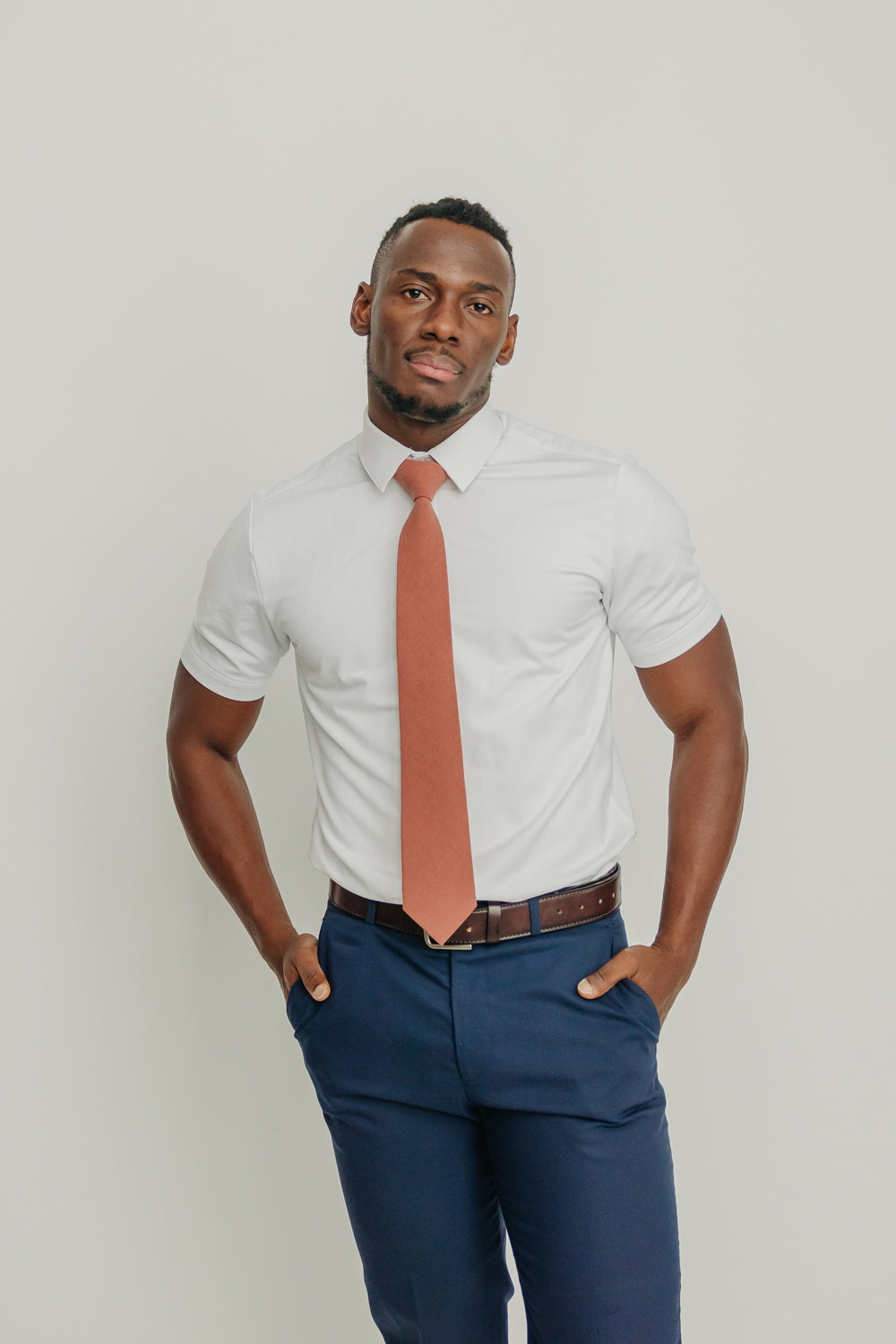 Sedona tie worn with a white shirt, brown belt and blue pants.