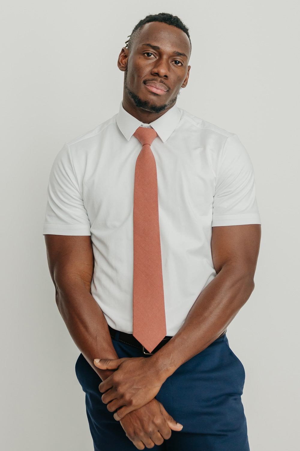 Sedona tie worn with a white shirt, brown belt and blue pants.