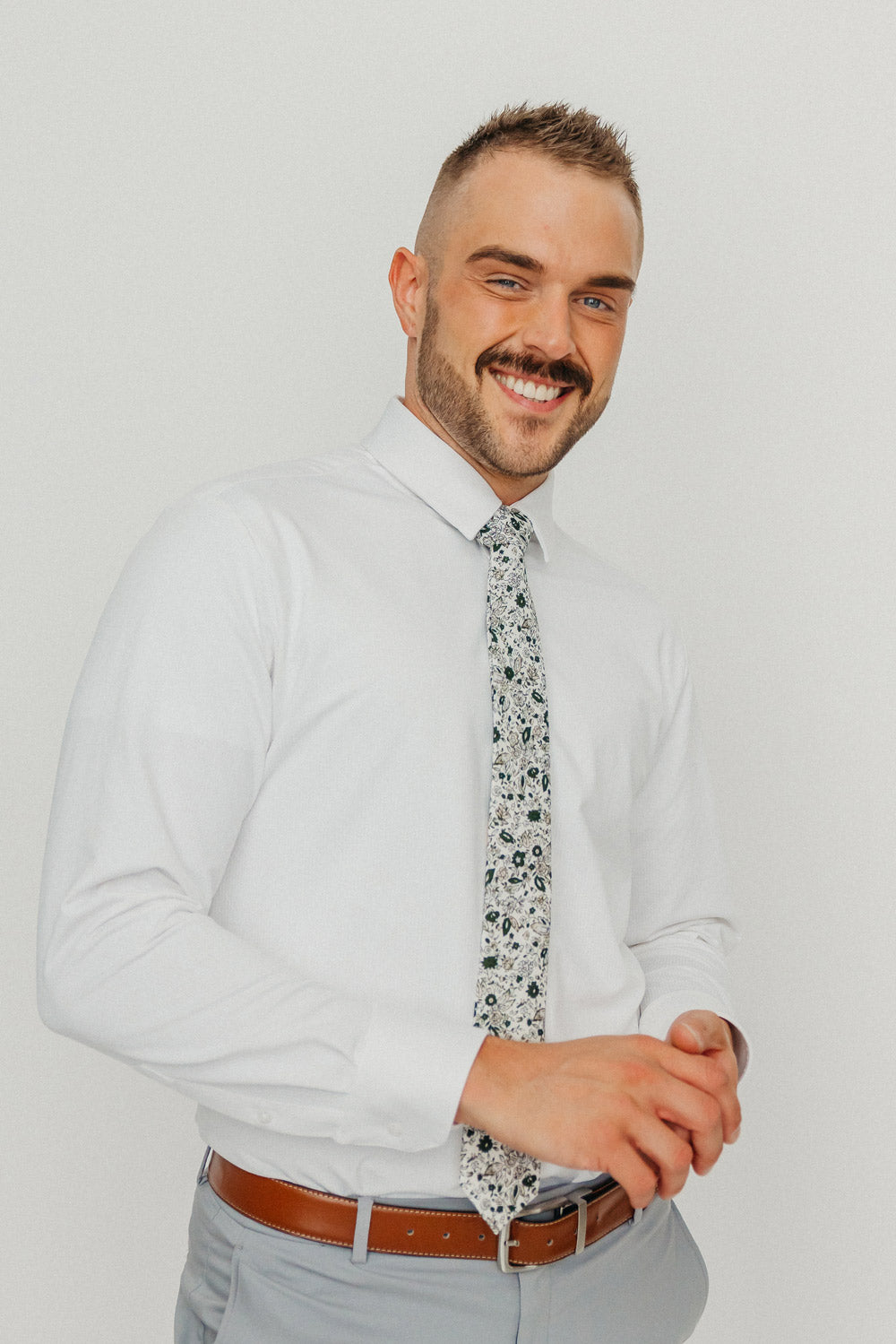 Silhouette tie worn with a white shirt, brown belt and gray pants.