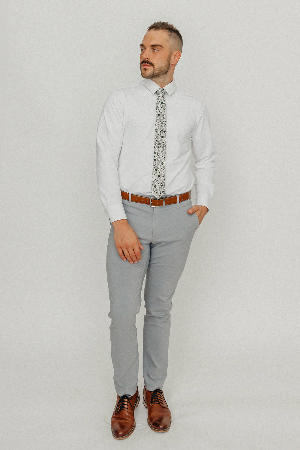 Silhouette tie worn with a white shirt, brown belt and gray pants.