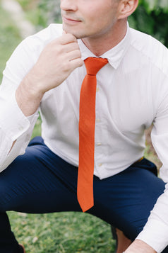 Tangerine tie worn with a white shirt.