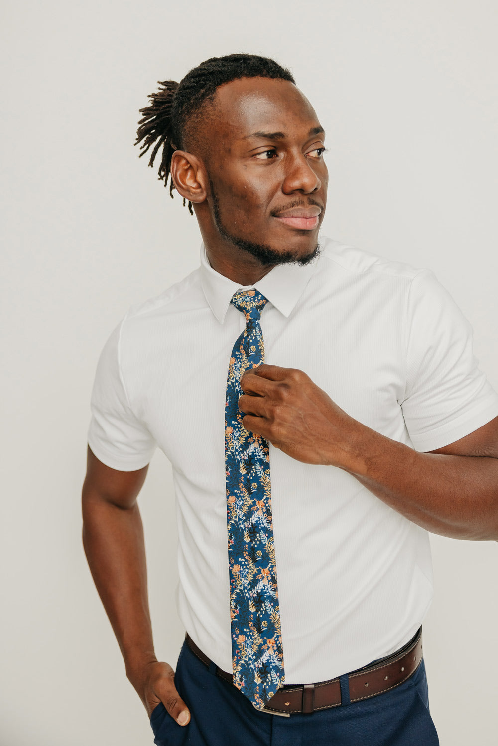 Tiger Lily tie worn with a white shirt, brown belt and blue pants.