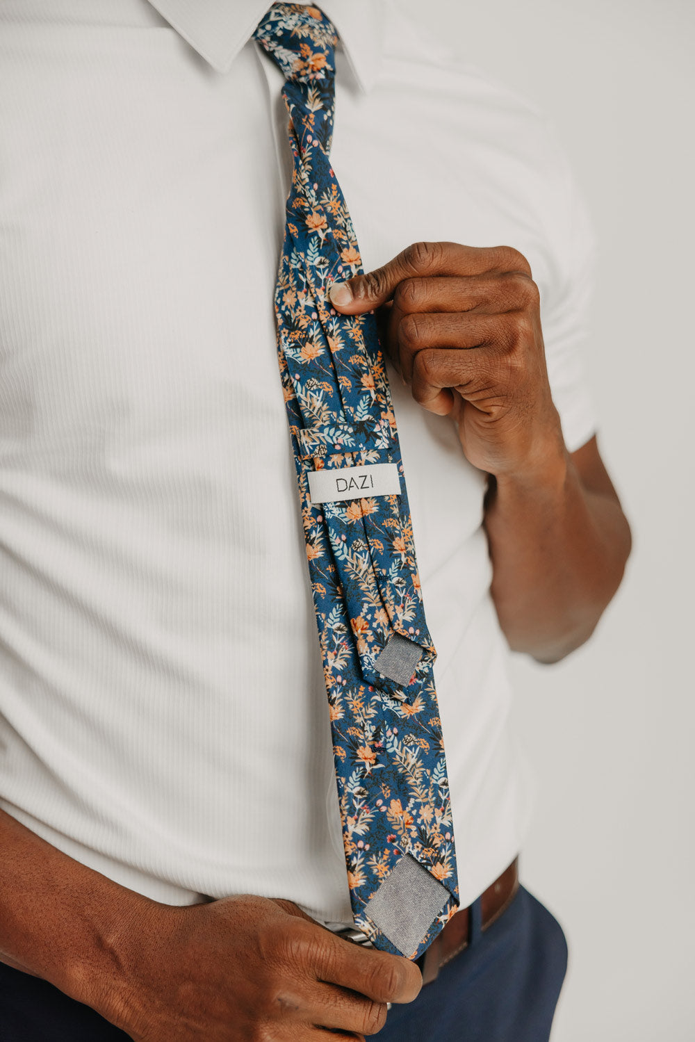 Tiger Lily tie worn with a white shirt, brown belt and blue pants.