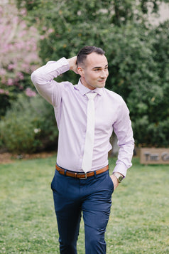 White tie worn with a light purple suit and blue suit pants.