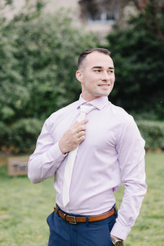 White tie worn with a light purple suit and blue suit pants.