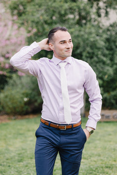 White tie worn with a light purple suit and blue suit pants.