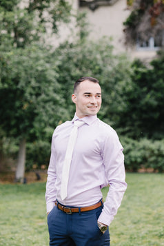 White tie worn with a light purple suit and blue suit pants.