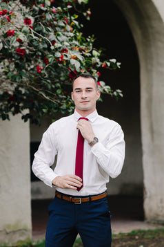 Wine necktie worn with a white shirt and blue pants. 