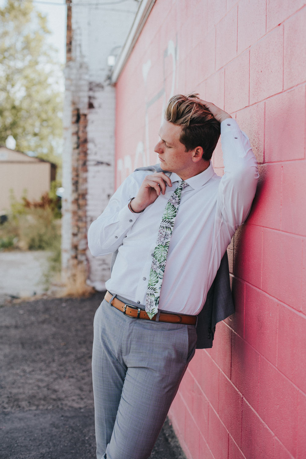 Aloe tie worn with a white shirt, gray suit, and brown belt. 