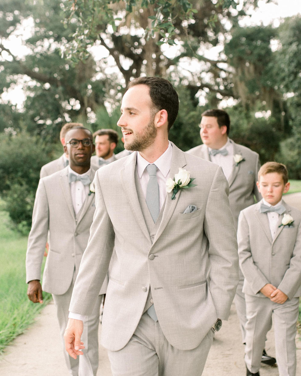 Dusty tie worn by groom at a wedding with white shirt and cream suit.