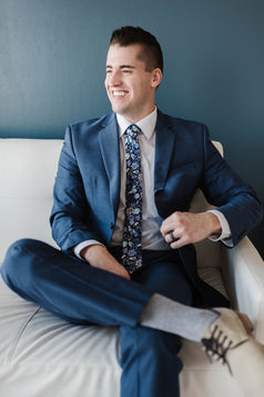 Lilac tie worn with a white shirt and blue suit.