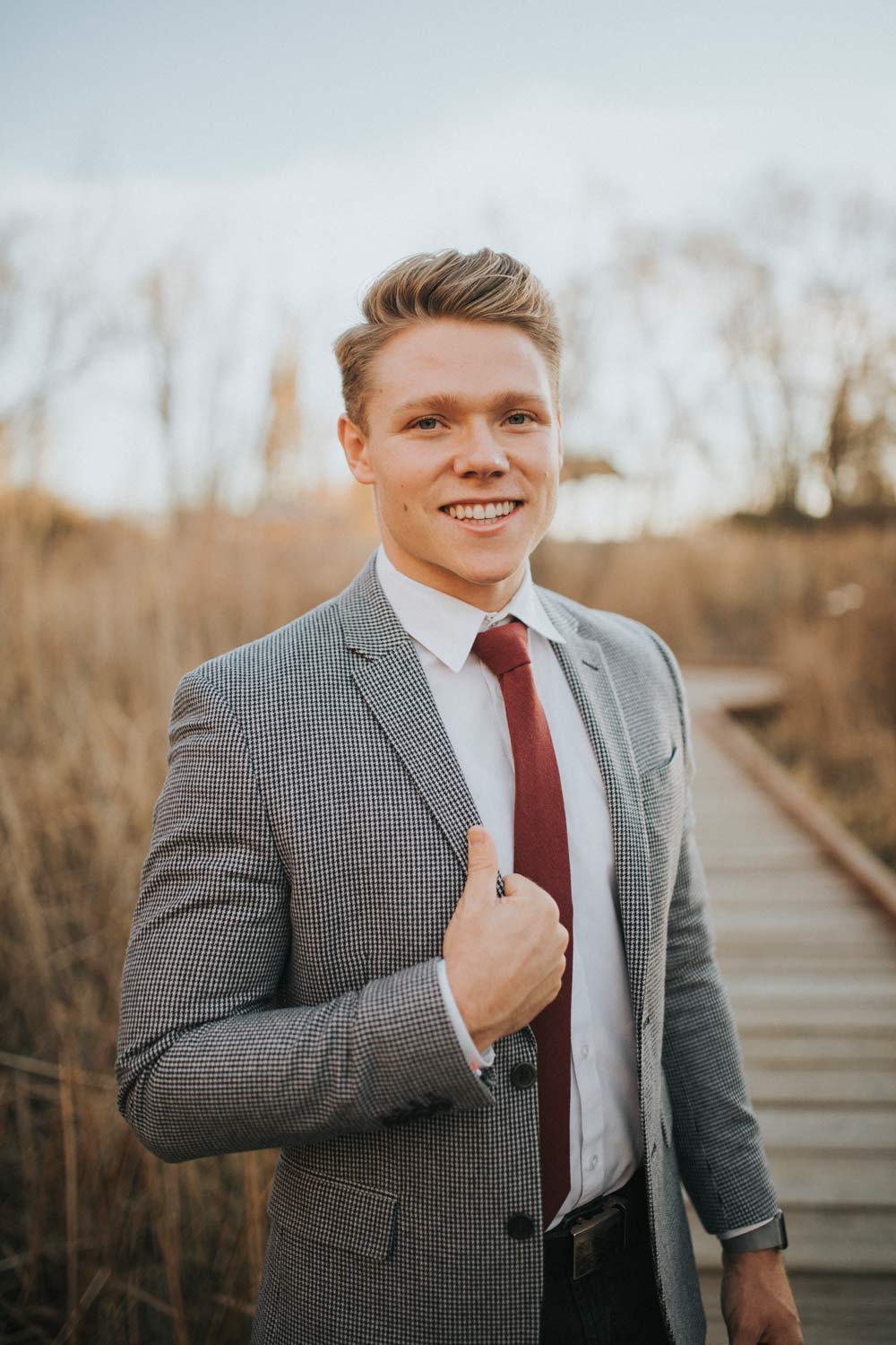 Merlot tie worn with a white shirt and gray textured suit jacket.