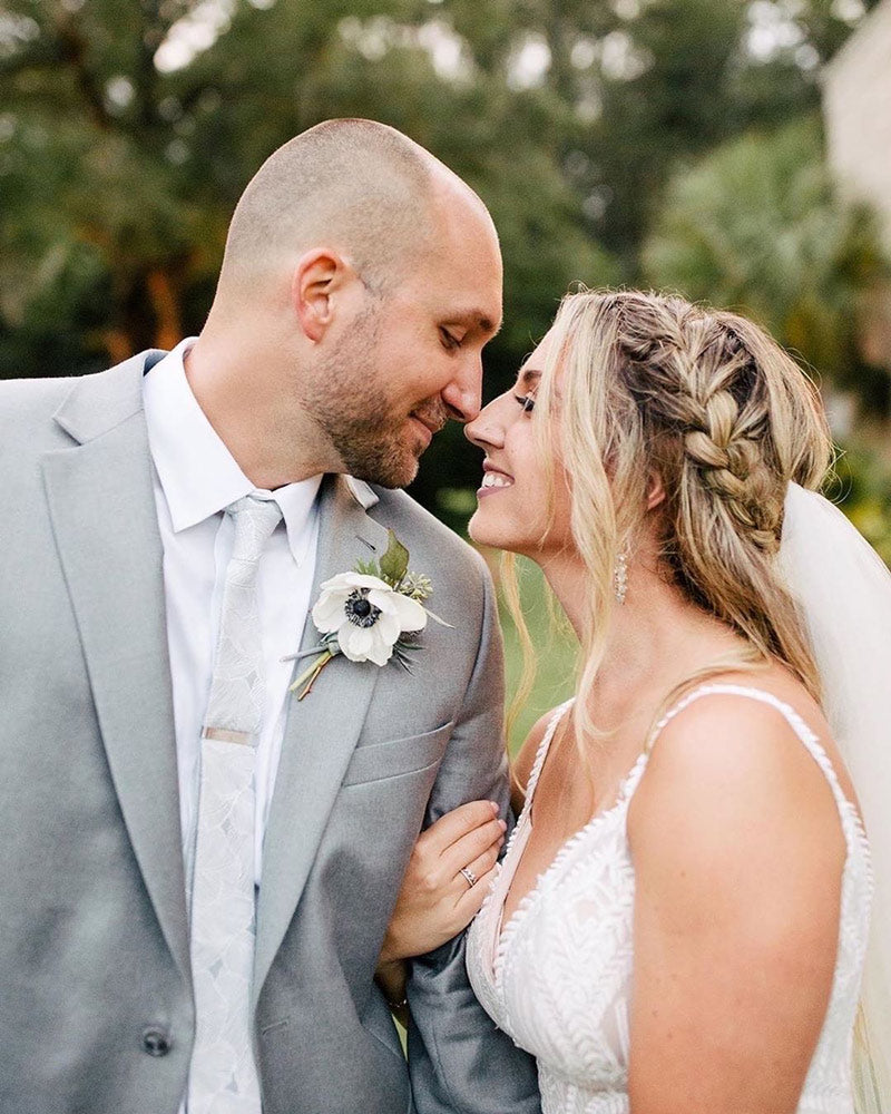 Palm tie worn by groom at a wedding with a white shirt and gray suit jacket.