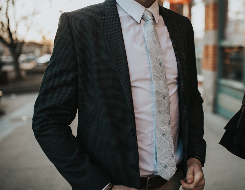 Palm tie worn with a white shirt and black suit jacket.