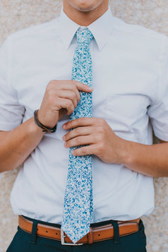 Powder tie worn with a white shirt, brown belt and navy blue pants.