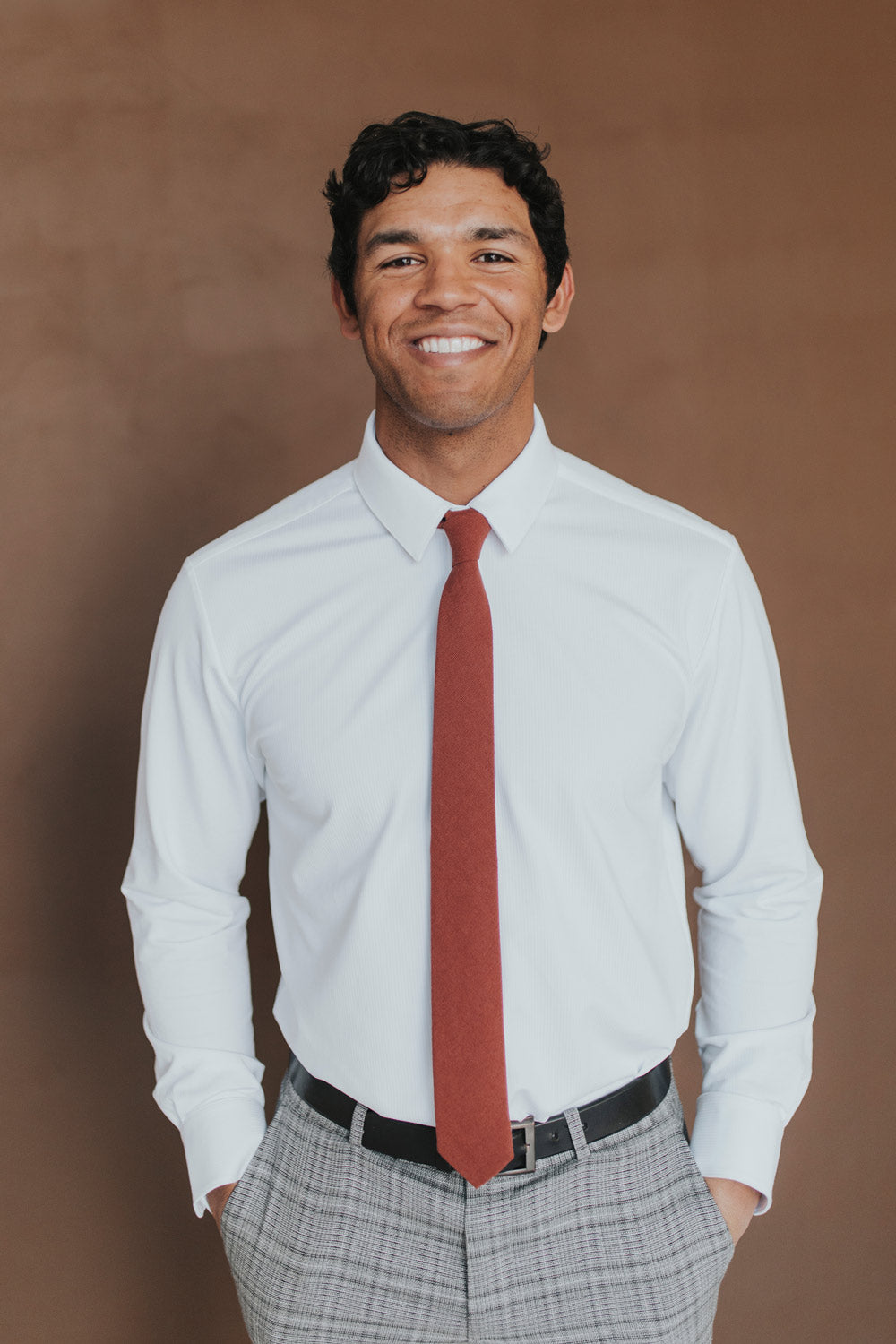 Rust Tie worn with a white shirt, black belt and gray plaid suit pants.