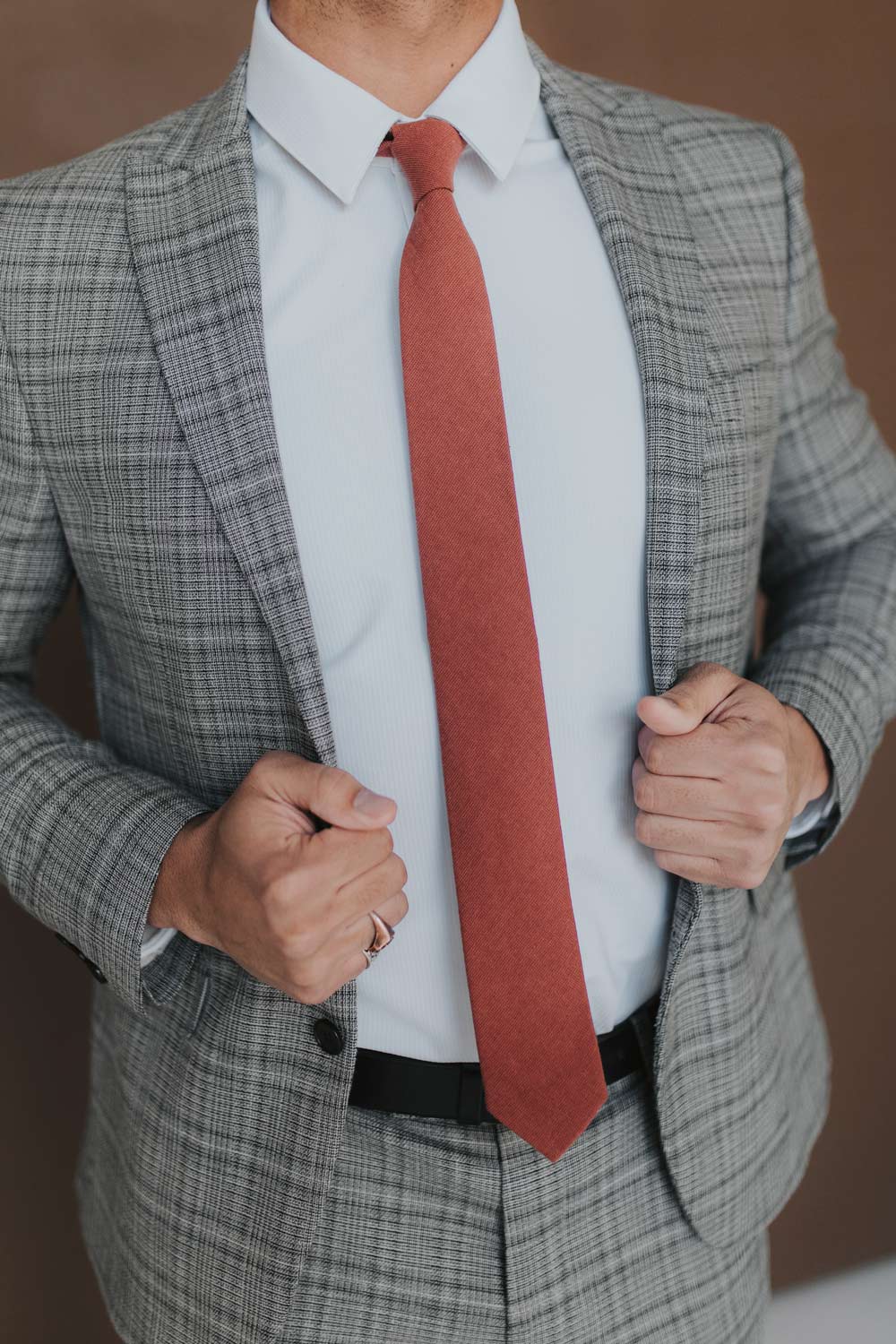 Rust Tie worn with a white shirt, black belt and gray plaid suit.