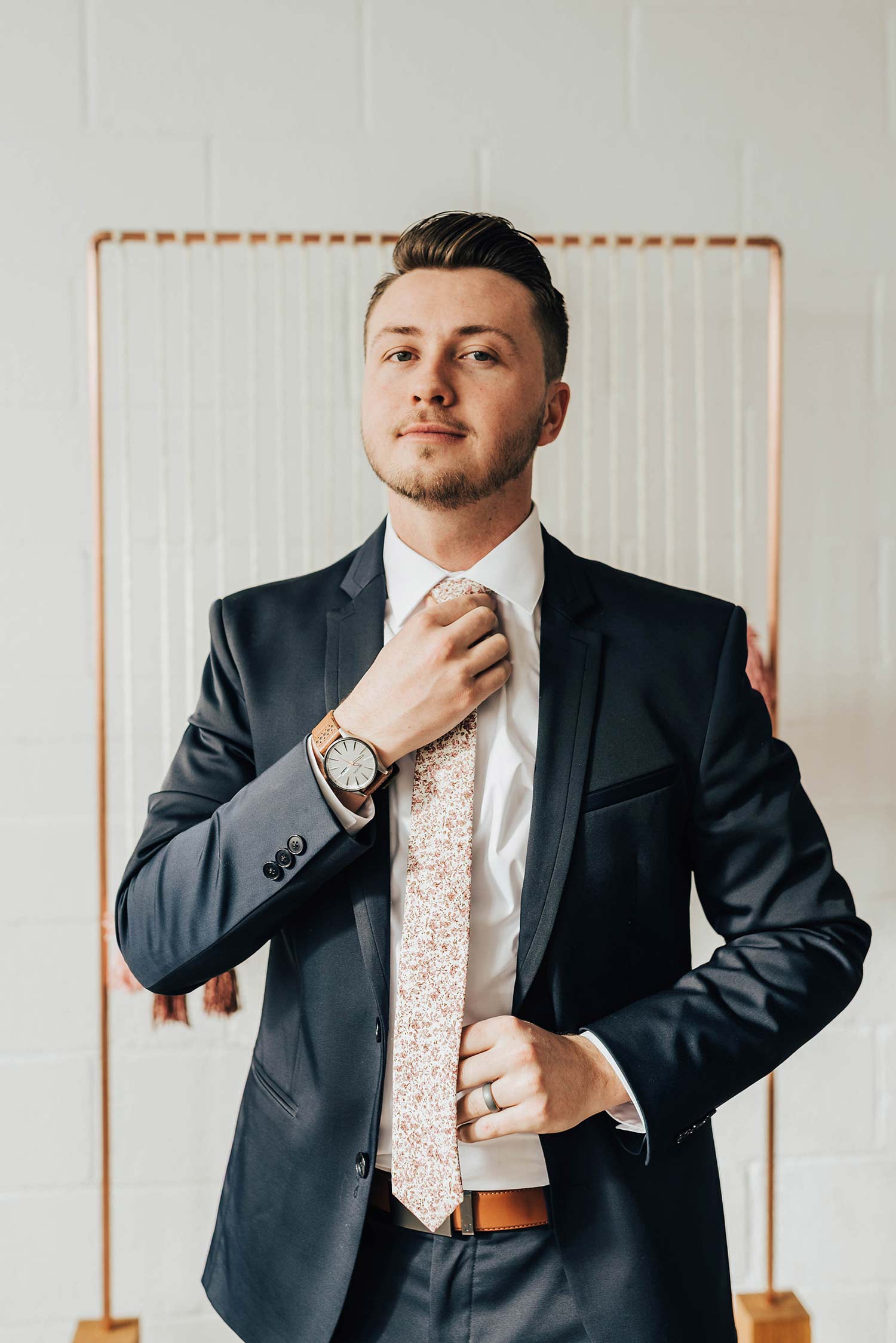 Ventura tie worn with a white shirt, brown belt and navy suit.